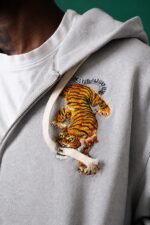 Détail de la broderie tigre sur la veste grise